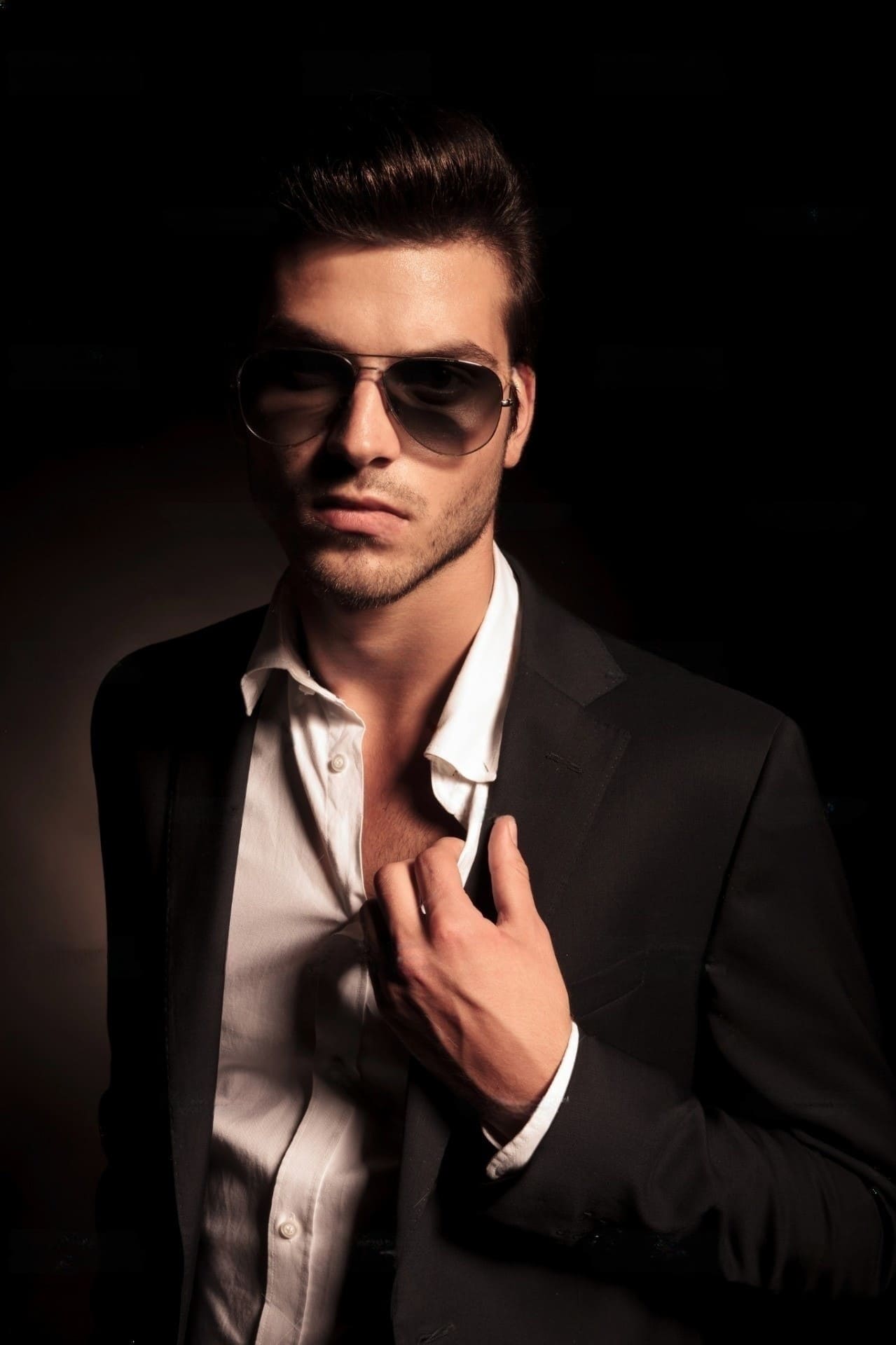 male model in a dark suit and white shirt wearing sunglasses