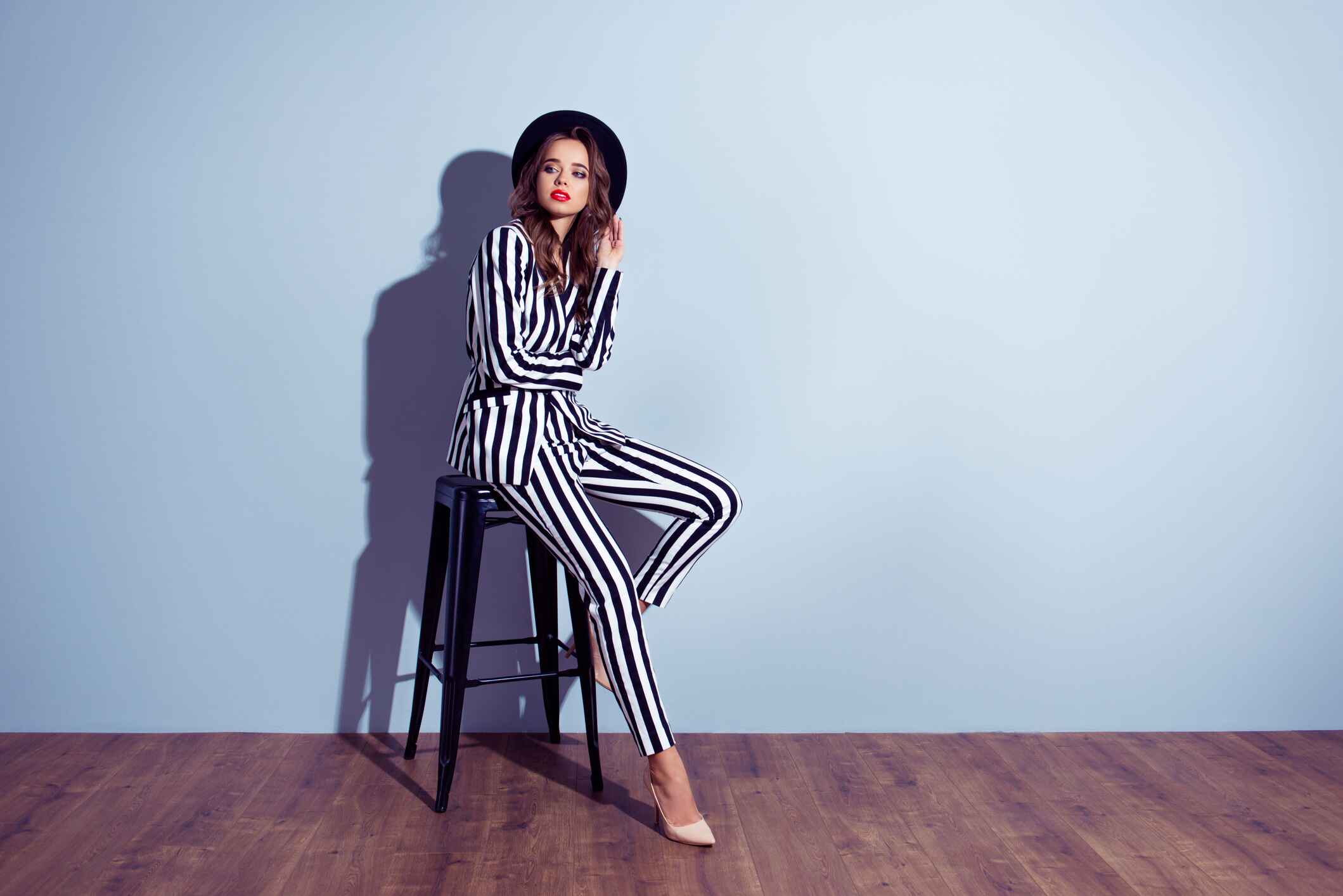 young woman in a black and white outfit posing on a chair